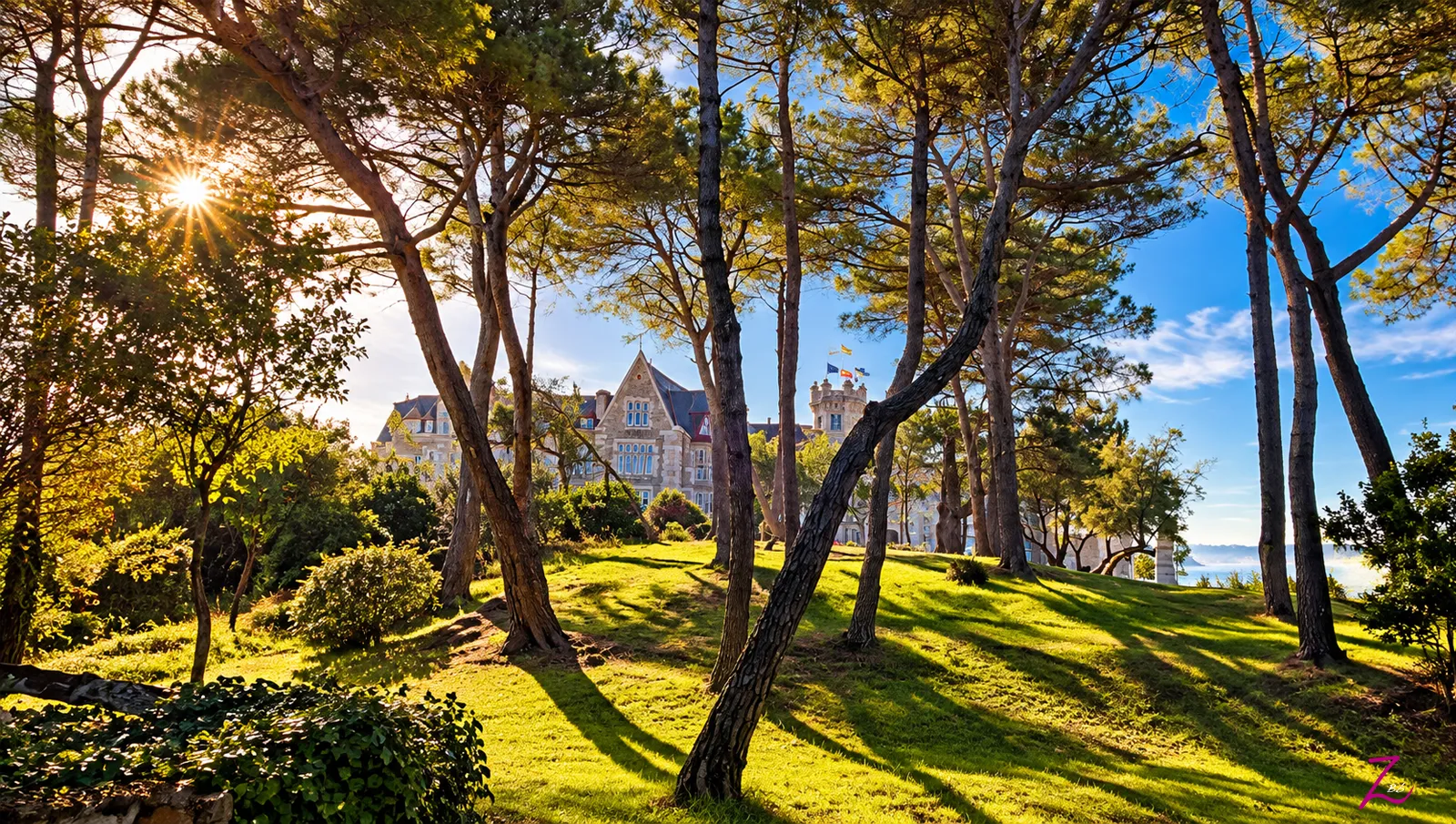 Palacio de la Magdalena en Santander entre los árboles y los jardines de la península, bajo la luz de un día soleado.