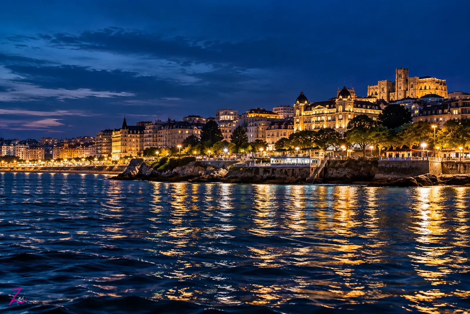 Santander iluminada al anochecer, contemplada desde el mar con reflejos dorados sobre el Cantábrico.